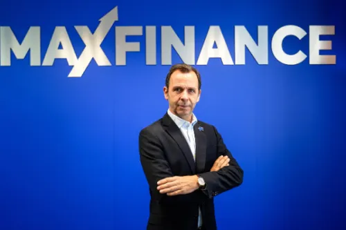 CEO Maxfinance de braços cruzados em fundo azul com logotipo