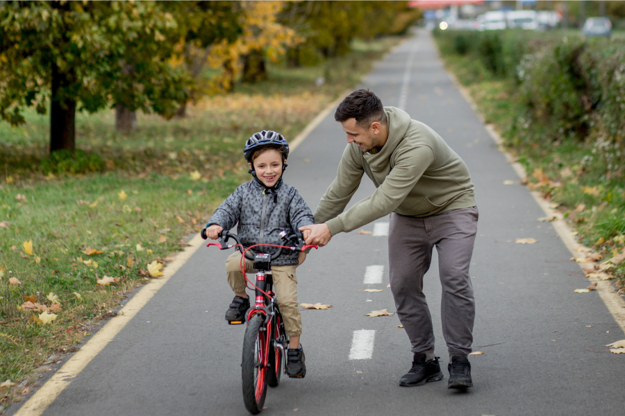 pai a ensinar o filhoa andar de bicicleta 